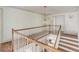 Staircase with wood handrail and floors, white risers, and globe pendant light at 19 Ponce De Leon Ave, Charleston, SC 29407
