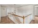 Staircase with wood handrail and floors, white risers, and globe pendant light at 19 Ponce De Leon Ave, Charleston, SC 29407