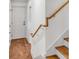 Staircase leading to an exterior door and featuring wooden banister with white walls at 19 Ponce De Leon Ave, Charleston, SC 29407