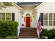 Close up on the front entryway, including a bright red door, black shutters, and American flag at 1971 N Smokerise Way, Mount Pleasant, SC 29466