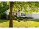 View of the front of the house through the green tree with a swing hanging from one of the branches at 1971 N Smokerise Way, Mount Pleasant, SC 29466