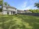 Spacious backyard with a lush lawn, a wooden fence, a firepit, and a screened-in porch at 2016 Elvington Rd, Johns Island, SC 29455