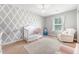Bedroom with geometrically designed accent wall, chandelier, and natural light at 2016 Elvington Rd, Johns Island, SC 29455