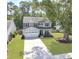 Charming two-story home with a well-manicured lawn, a two-car garage, and mature trees, providing a welcoming curb appeal at 2016 Elvington Rd, Johns Island, SC 29455