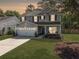 Charming two-story home with a well-manicured lawn, attached garage, and inviting front porch at 2016 Elvington Rd, Johns Island, SC 29455