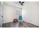 Cozy bedroom with gray wood floors, ceiling fan, and a glider chair by a window at 203 Eagle Ridge Rd, Summerville, SC 29485