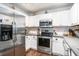 Updated kitchen with stainless steel fridge, range, microwave, white cabinets and dark countertops at 203 Eagle Ridge Rd, Summerville, SC 29485