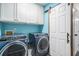 Updated laundry area with blue washer/dryer set, cabinets, and sliding door at 203 Eagle Ridge Rd, Summerville, SC 29485