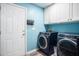 Laundry room with stylish washer and dryer, cabinets, laundry decor, and painted blue at 203 Eagle Ridge Rd, Summerville, SC 29485