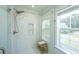 Bright bathroom featuring glass shower with subway tile and a wooden seat near the window at 203 O'Malley Dr, Summerville, SC 29483