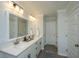 Well-lit bathroom with double sink vanity, large mirror and cabinets, and decorative tile floor at 203 O'Malley Dr, Summerville, SC 29483