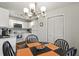 Kitchen dining area featuring a modern chandelier, a dark wood table, and white cabinetry nearby at 2030 Coldspring Dr # 708, North Charleston, SC 29406
