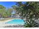 Refreshing community swimming pool featuring clear blue water, concrete surroundings, and partial tree coverage at 2030 Coldspring Dr # 708, North Charleston, SC 29406