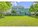 Expansive backyard showcasing a lush lawn, patio seating, and the home's charming exterior, ideal for outdoor enjoyment at 219 Silverwood Ln, Summerville, SC 29485