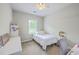 This single bedroom features a white bed, desk, chair, and bright window at 219 Silverwood Ln, Summerville, SC 29485