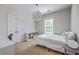 This neutral bedroom features a unique light fixture, a bright window, and a white bed at 219 Silverwood Ln, Summerville, SC 29485