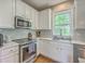 Charming kitchen features white cabinets, stainless steel appliances, and ample counter space for cooking at 219 Silverwood Ln, Summerville, SC 29485