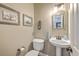 This neutral powder room features framed art, a pedestal sink, an ornate mirror, and updated fixtures at 219 Silverwood Ln, Summerville, SC 29485