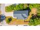 Aerial view of a home with a dark roof, surrounded by lush green trees and a well-maintained yard at 2501 Myrtle St, Edisto Beach, SC 29438