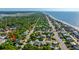 Aerial view showcases this property near the coast and the neighborhood, full of lush green trees at 2501 Myrtle St, Edisto Beach, SC 29438
