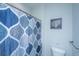 Cozy bathroom with a toilet, blue patterned shower curtain, and nautical artwork for a beachy vibe at 2501 Myrtle St, Edisto Beach, SC 29438