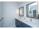 Modern bathroom with double sinks, quartz countertop, framed mirrors, and decorative sconces at 2501 Myrtle St, Edisto Beach, SC 29438