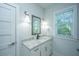 This bathroom has a white vanity with granite counter, framed mirror, and sconce lighting at 2501 Myrtle St, Edisto Beach, SC 29438