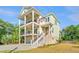 Charming coastal home featuring multiple decks, a well-manicured lawn, and lovely curb appeal at 2501 Myrtle St, Edisto Beach, SC 29438