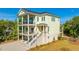Charming home with multi-level balconies and inviting front entrance, showcasing coastal living at its finest at 2501 Myrtle St, Edisto Beach, SC 29438