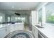 Modern kitchen with white cabinetry, stainless steel appliances, and a view into the living room at 2501 Myrtle St, Edisto Beach, SC 29438
