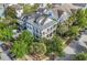 Aerial view of a beautiful home with manicured yard, screened porch, firepit, and surrounding green trees at 2522 Daniel Island Dr, Daniel Island, SC 29492