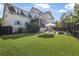 Spacious backyard with lush green lawn, stone patio, outdoor furniture, and mature landscaping at 2522 Daniel Island Dr, Daniel Island, SC 29492