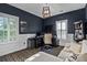 Home office with dark blue walls, white trim, built-in shelving, and two windows that provide lots of light at 2522 Daniel Island Dr, Daniel Island, SC 29492