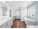Bright bathroom featuring double vanity, soaking tub, and a frameless glass shower at 2522 Waverly St, Charleston, SC 29492