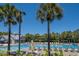 Sparkling community pool surrounded by palm trees and lounge chairs on a sunny day at 2522 Waverly St, Charleston, SC 29492