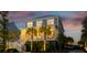 Beautiful two-story home featuring a metal roof, and a welcoming front porch at dusk at 2522 Waverly St, Charleston, SC 29492