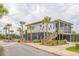 Exterior view of a coastal-style building with palm trees, a screened porch, and staircase at 2522 Waverly St, Charleston, SC 29492