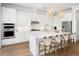 A chef's kitchen featuring a large island, white cabinets, stainless appliances, and stylish pendant lighting at 2522 Waverly St, Charleston, SC 29492