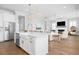 Open concept kitchen with white cabinets, stainless appliances, island with seating, and views to the living room at 2522 Waverly St, Charleston, SC 29492