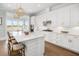 A chef's kitchen with a large island, white cabinets, stainless appliances, and modern pendant lighting at 2522 Waverly St, Charleston, SC 29492