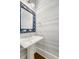 Stylish powder room features designer wallpaper, pedestal sink, and elegant mirror with decorative frame at 2522 Waverly St, Charleston, SC 29492