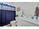 Clean bathroom features a white vanity and a blue shower curtain for a fresh look at 2557 Hatch Dr, Johns Island, SC 29455
