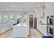 Bright kitchen with modern appliances, a large island, and a cozy living area in the background at 2557 Hatch Dr, Johns Island, SC 29455