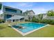 Inviting pool area with in-pool loungers and a large umbrella, surrounded by well-maintained turf and neighboring homes at 2557 Hatch Dr, Johns Island, SC 29455