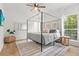 Light-filled bedroom featuring a canopy bed, modern ceiling fan, and a large window at 2560 Palmetto Hall Blvd, Mount Pleasant, SC 29466