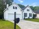 Front exterior showcasing the attached two-car garage, well-maintained lawn and landscaping of this lovely home at 2560 Palmetto Hall Blvd, Mount Pleasant, SC 29466