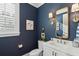 Charming bathroom features a gold-framed mirror, stylish fixtures and dark blue walls at 2578 Helmsman Rd, Johns Island, SC 29455