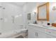 Bright bathroom with a glass shower, subway tile, white vanity, and decorative woven-framed mirror at 2578 Helmsman Rd, Johns Island, SC 29455