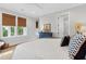 Bedroom featuring a white bed, patterned pillows, windows, and minimalist decor at 2578 Helmsman Rd, Johns Island, SC 29455