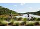 Scenic view of women biking along a trail by the water, surrounded by lush greenery and blue skies at 2578 Helmsman Rd, Johns Island, SC 29455